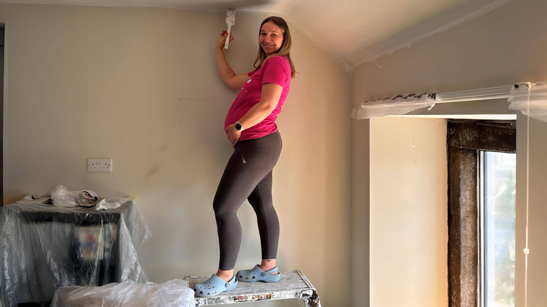 Pregnant woman holding decorating paint brush 